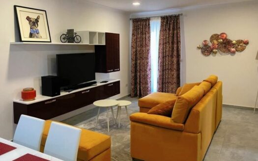 Moderno salone di quadrilocale a Malta, comprende divano arancione, TV piatta, finestra.