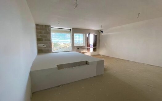 Interno di un trilocale in costruzione a Malta con ampio spazio aperto e finestra panoramica