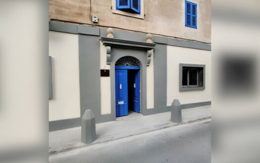 Finestra con persiane blu e porta ornata di un edificio tradizionale a Rabat, Malta